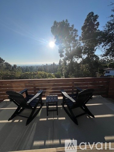 A sunny day with a table and chairs on a balcony.