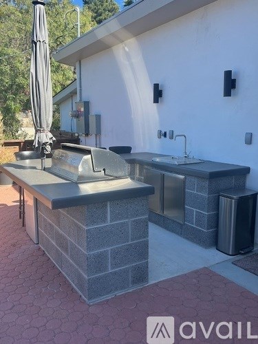 A patio with a sink and umbrella.