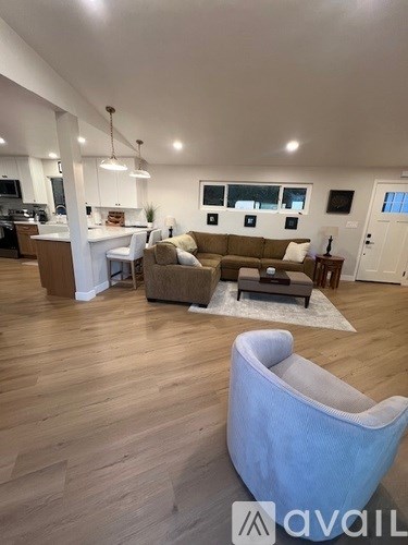 A living room with a white sofa and a grey armchair.