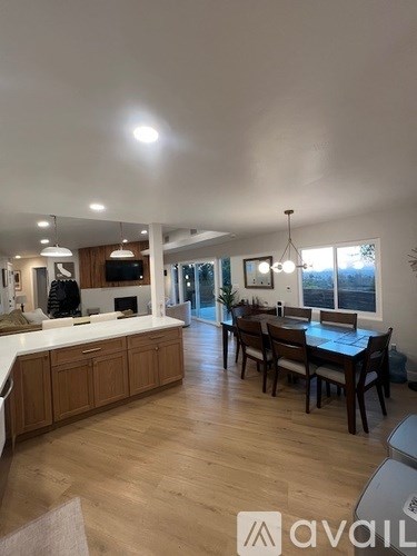 A modern kitchen with wooden cabinets and a dining table.