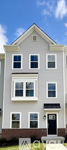 A two-story house with a black door and white trim.