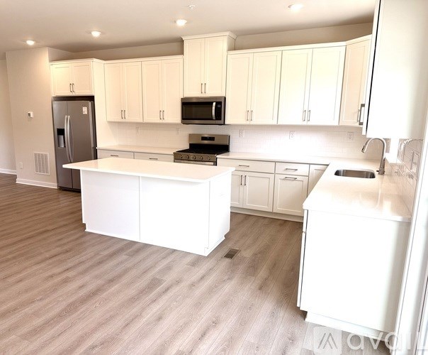 A kitchen with white cabinets and appliances.