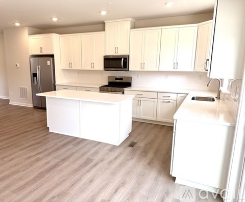A kitchen with white cabinets and appliances.