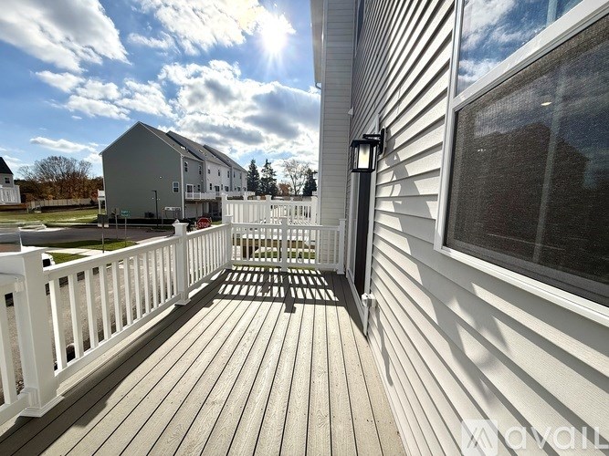 A sunny day on a wooden deck with a white railing.