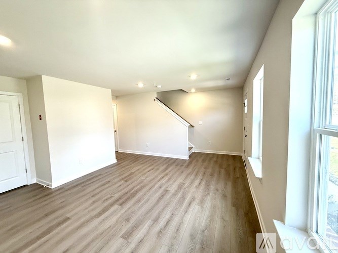 A room with wooden flooring and white walls.
