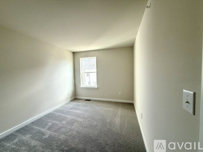 A room with a carpeted floor and a window.