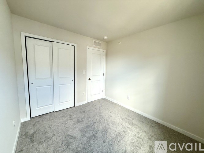 A room with two doors and a carpeted floor.