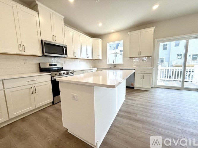 A kitchen with white cabinets and a large island.