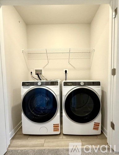 Two front loading washing machines in a small laundry room.