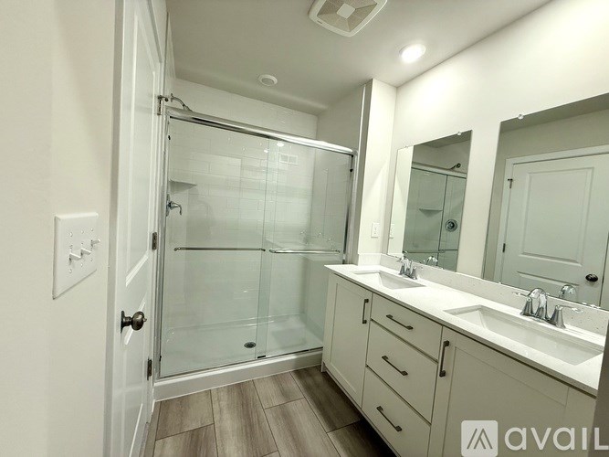 A bathroom with a walk-in shower and double sinks.