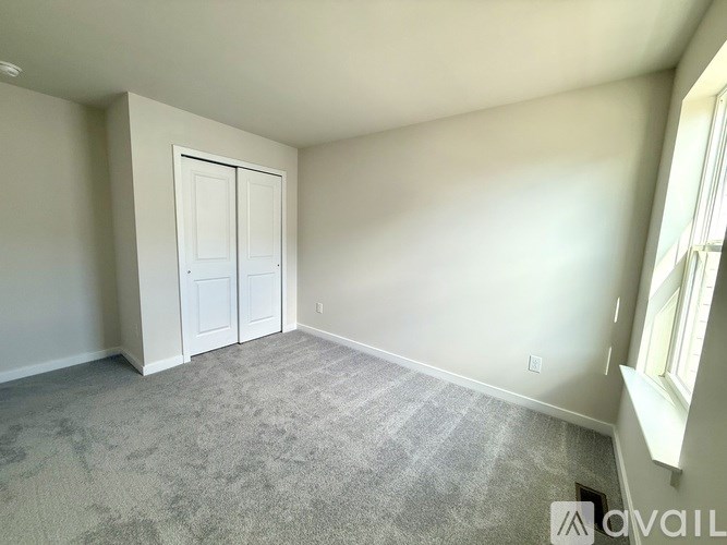 A room with a carpeted floor and a white door.