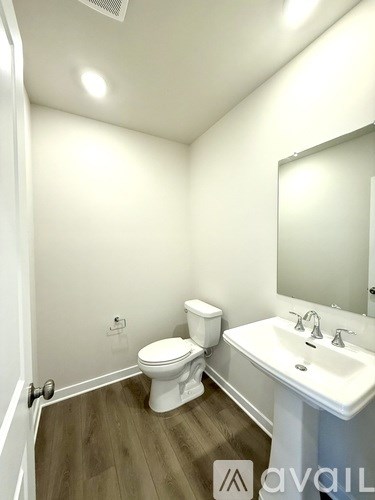 A white toilet sits in a small bathroom next to a sink.