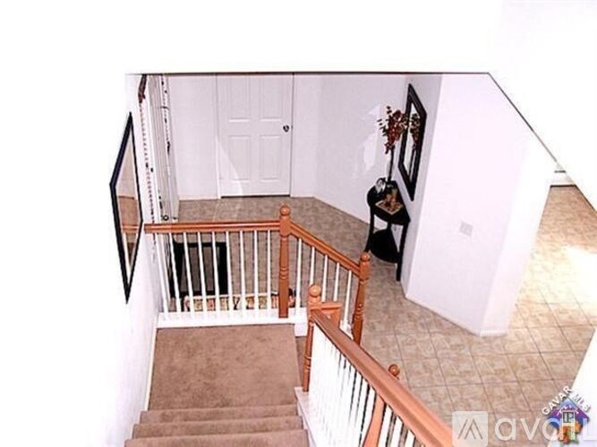 A staircase with a carpeted runner and wooden banister.