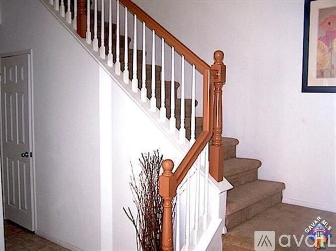A staircase with a white railing and a brown handrail.