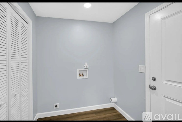 A room with a white door and a white cabinet with a light switch.