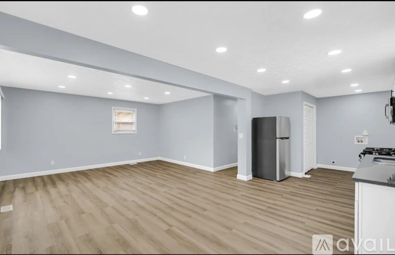 A spacious kitchen with a refrigerator and a countertop.