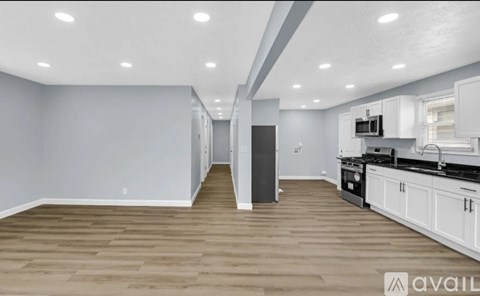 A spacious kitchen with white cabinets and a black countertop.