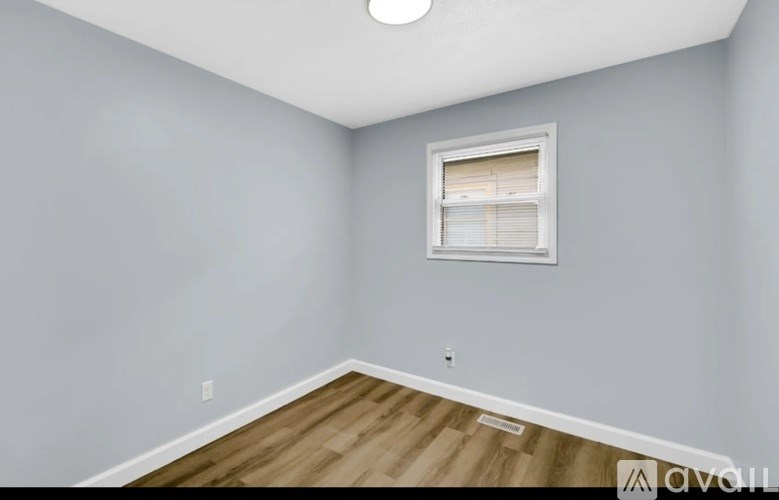 A room with a window and wooden flooring.