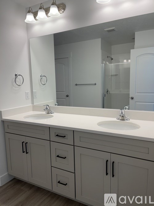 A bathroom with two sinks and a large mirror.