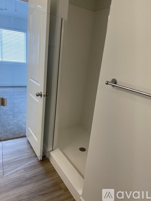 A white door with a glass panel is open to a hallway.