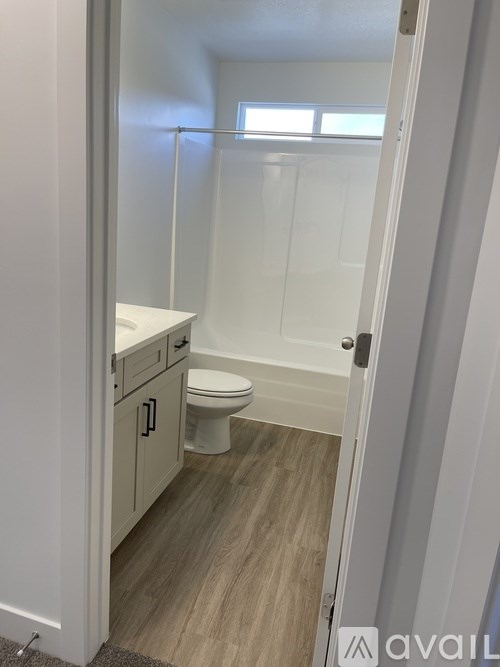 A bathroom with a toilet, sink and cabinet.