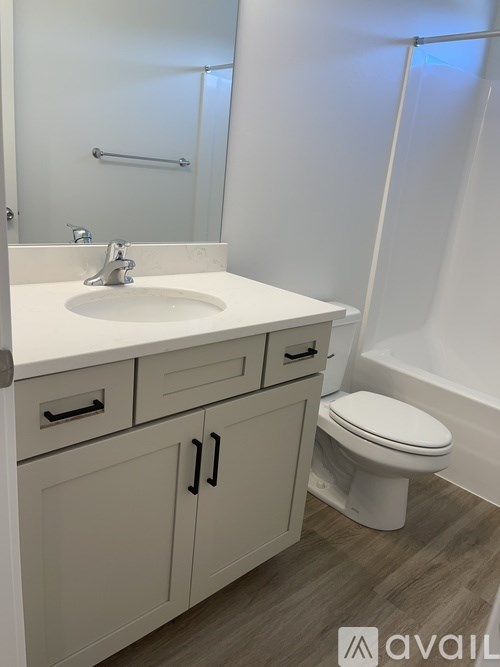 A bathroom with a sink, toilet, and a mirror.