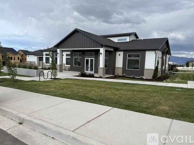 A house with a grey roof and white walls is available for sale.