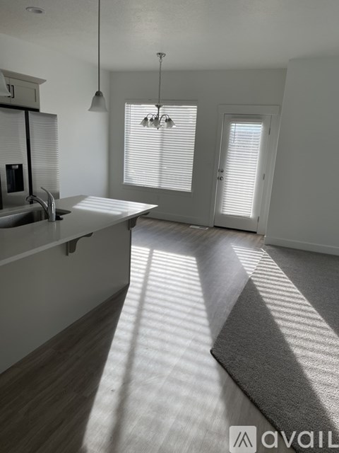 A sunlit kitchen with a dining table and chairs.