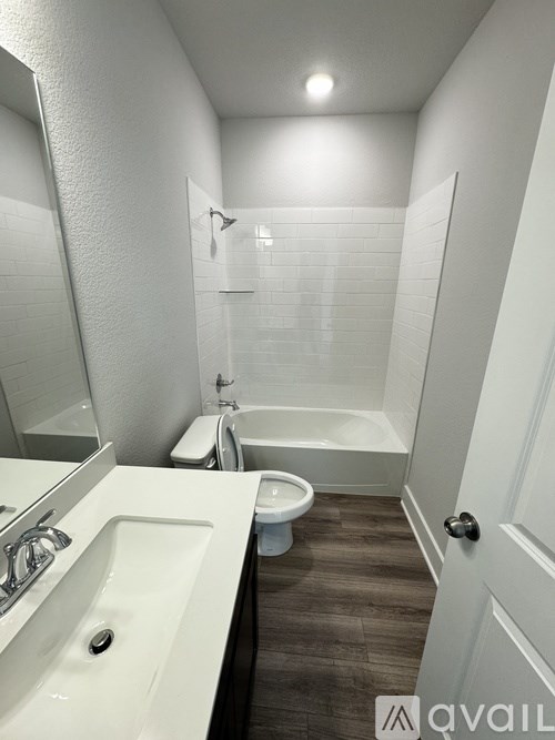 A bathroom with a toilet, sink, and bathtub.