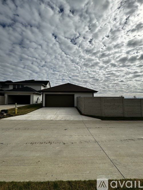 A house with a garage and a driveway in front of it.