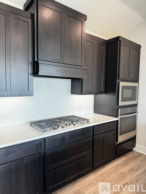 A kitchen with dark wood cabinets and a white countertop.