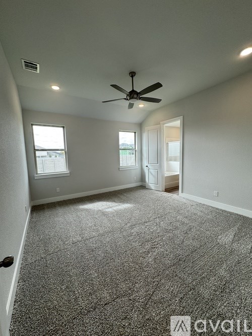 A room with a ceiling fan and carpeted floor.