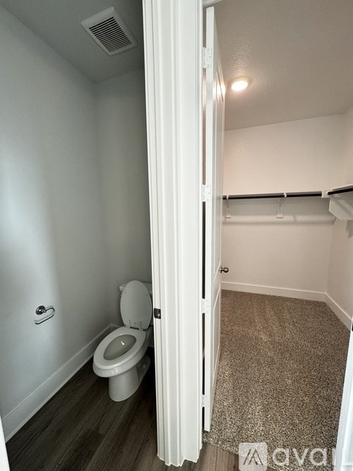 A small bathroom with a toilet and a carpeted floor.