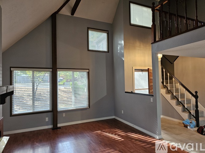 A living room with a staircase and a window.