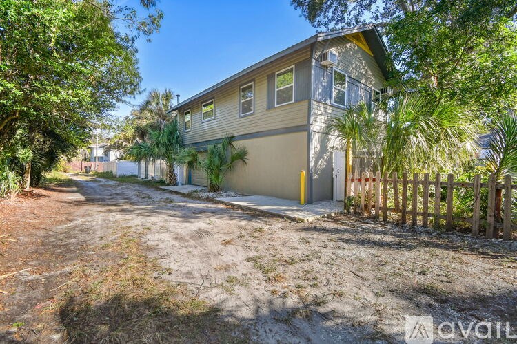 A house with a fence and trees in front of it.