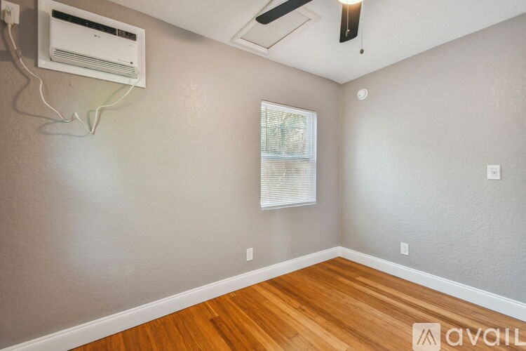 A room with a window and a wall-mounted air conditioner.