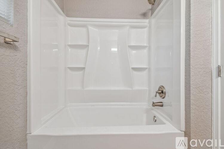 A white bathroom with a tub and toiletries.