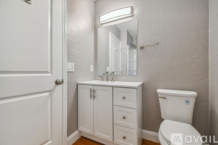 A white bathroom with a toilet, sink, and medicine cabinet.