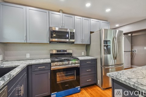 A kitchen with a stove top oven and a refrigerator.