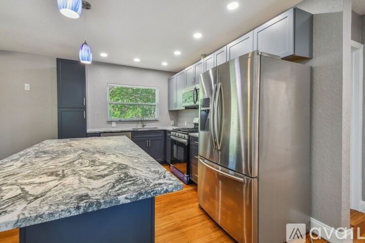 A kitchen with a marble countertop and stainless steel appliances.