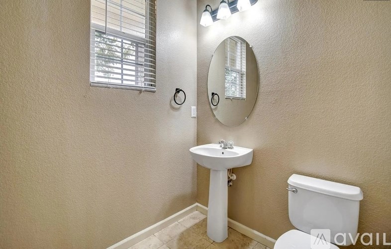 A bathroom with a sink, toilet, and mirror.