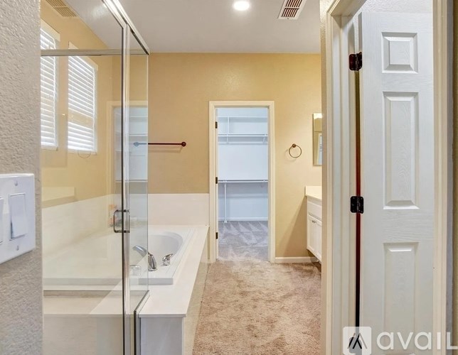 A bathroom with a glass shower door and a white sink.
