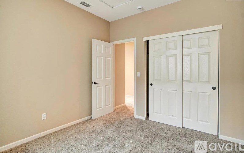 A room with two white doors, one open and one closed.