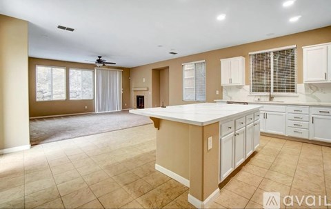 A spacious kitchen with beige cabinets and a large island.