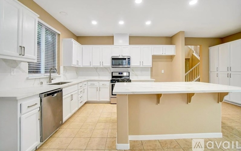 A kitchen with white cabinets and appliances.