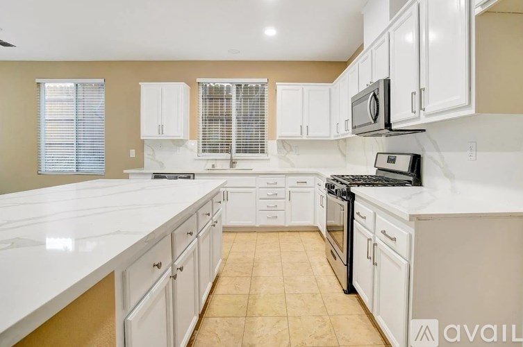 A kitchen with white cabinets and appliances.