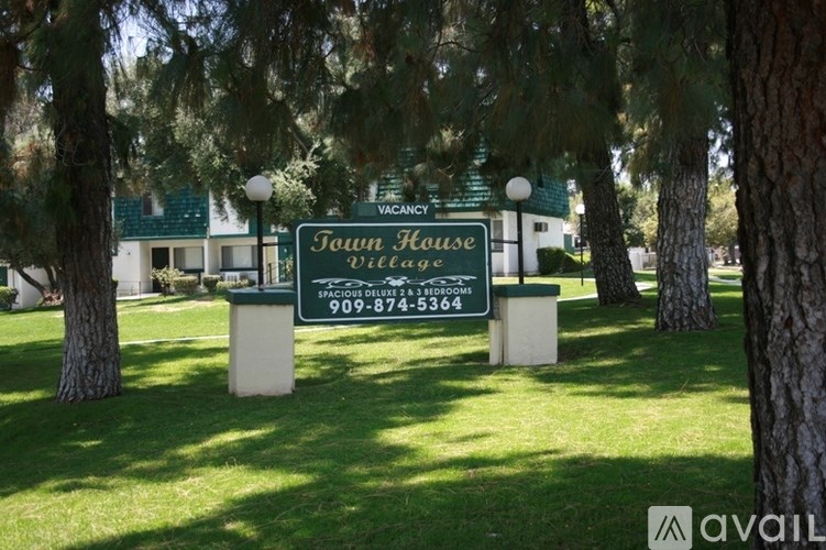 A sign for a vacation townhouse village with a phone number on it.