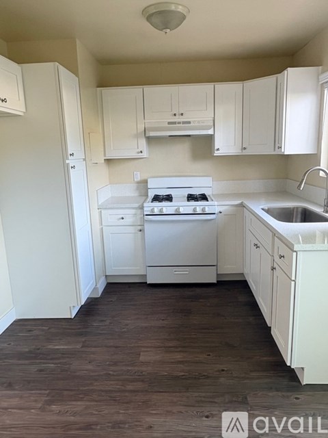A kitchen with white appliances and cabinets.