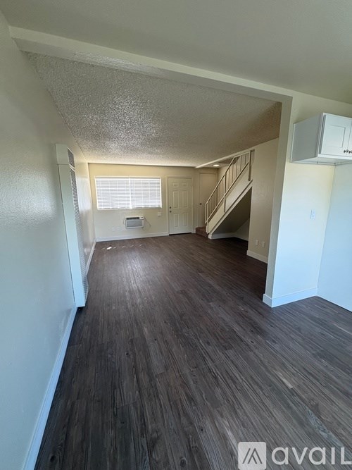 A room with wooden floors and a staircase.
