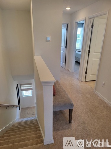 A hallway with a staircase leading to a bedroom.